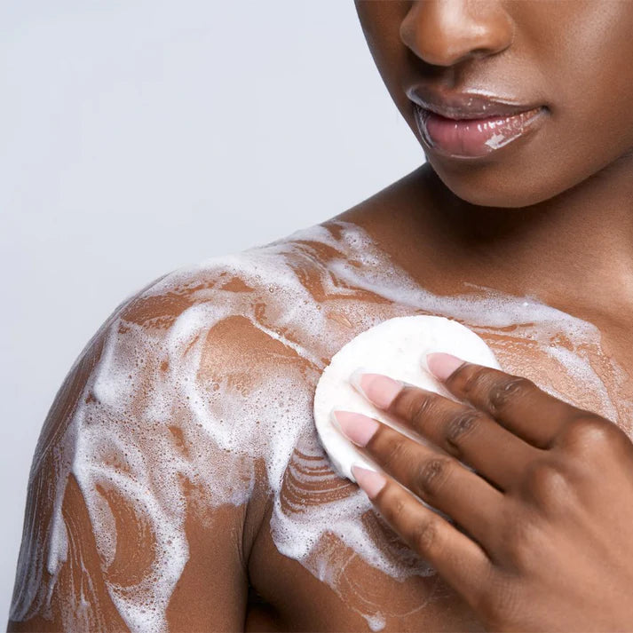 Woman applying soap to her shoulder with a white background | Makari de Suisse Uganda